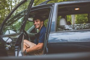 man inside vehicle in front of opened door